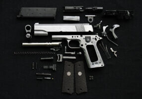 Disassembled handgun on black background, ; Shutterstock ID 220531096; purchase_order: -; job: -; client: -; other: -